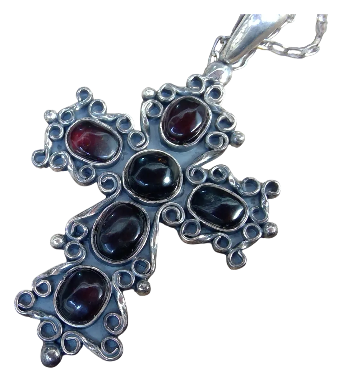 Cruz de plata con volutas y siete piedras color vino